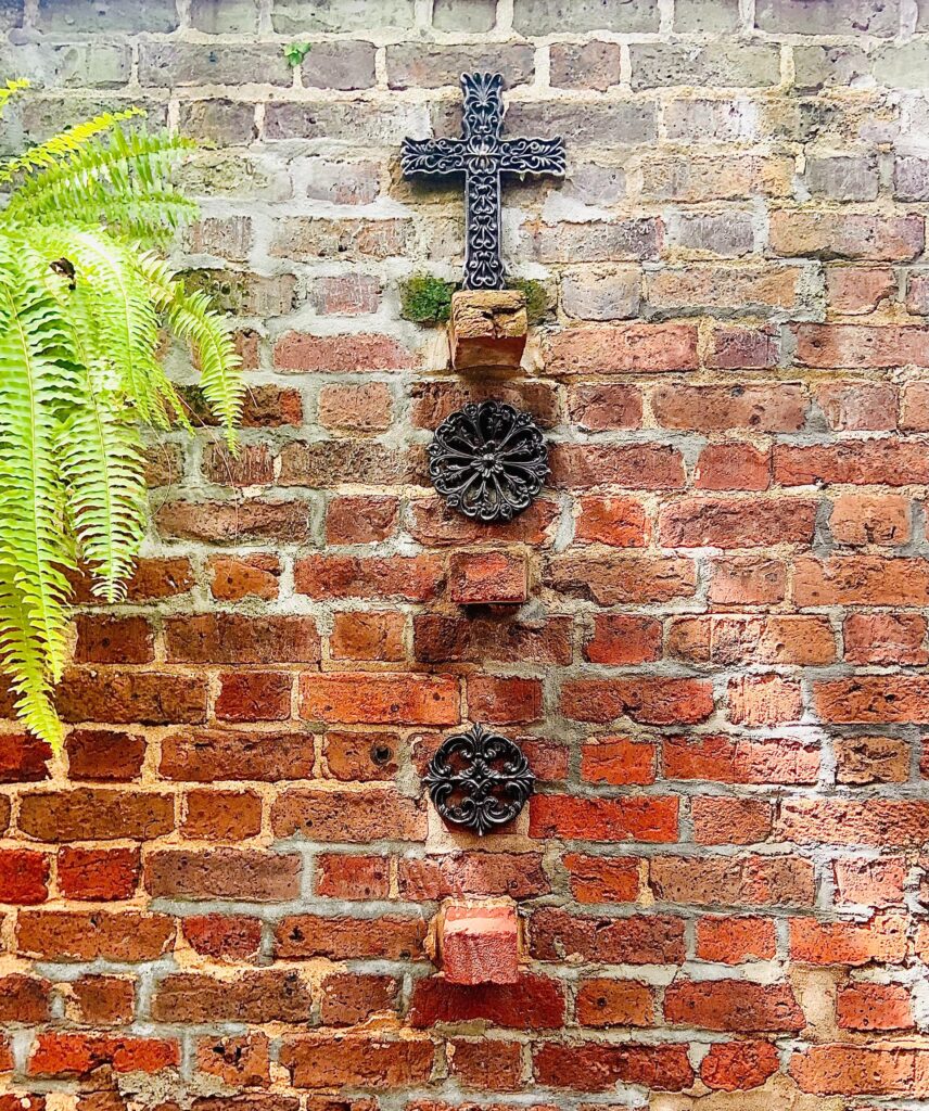 Religious symbolic artifacts displayed against a brick wall.